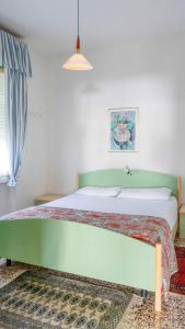 a bedroom with a large bed with a green headboard at Villa Gasparina in Ronchi