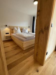 a bedroom with a bed and a wooden floor at Ferienwohnungen Alpinum in Krün
