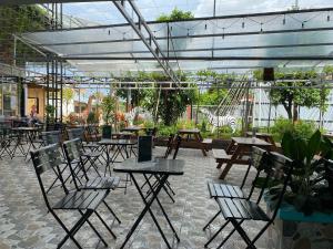 eine Terrasse mit Tischen und Stühlen in einem Gebäude in der Unterkunft Motel Nhật Quang(HẢO BÙI) in Bạc Liêu