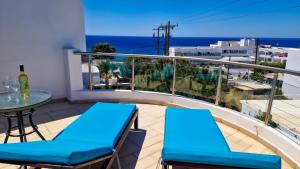 a balcony with a table and chairs and the ocean at Grapevines Villas Makrygialos in Makry Gialos