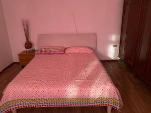 - une chambre avec un lit doté d'un couvre-lit rose et d'oreillers dans l'établissement Rafin’s turistico agricoltura, à Malcontenta