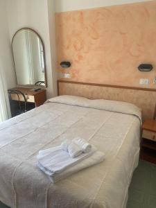 un letto con due asciugamani sopra di Hotel Tyc Soleti Hotels a Rimini