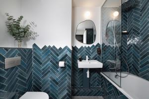 a bathroom with a blue and white tiled wall at Hôtel de la Couronne in Chamonix