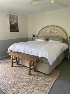 um quarto com uma cama grande e um banco de madeira em GARRU FARM…. A perfect rustic farm stay near Orange em Orange