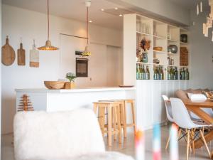 Horizon P'y في Puéchoursi: مطبخ وغرفة معيشة مع بار وكراسي