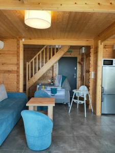 a living room with a blue couch and a kitchen at DOMY MARINA VILLAGE in Kąty Rybackie