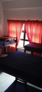 una camera con letto e finestra con tende rosse di Blue-Sky Wave ad Antipolo