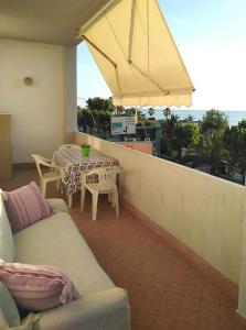 een woonkamer met een bank en een tafel op een balkon bij Terrazza sul Mare in Alba Adriatica