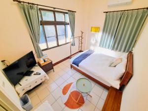Schlafzimmer mit einem Bett und einem Fenster in der Unterkunft Rainy Pleasure in Meishan