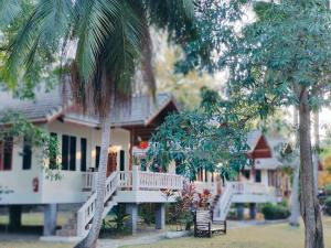 een wit huis met palmbomen ervoor bij MY HOME Resort - Koh phangan vacation house rentals in Ban Madua Wan