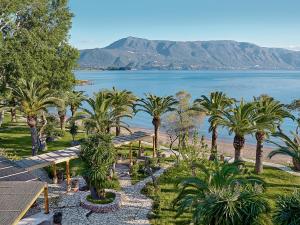 een uitzicht op een resort met palmbomen en het water bij Grecotel-LUXME Daphnila Bay Dassia in Dassia