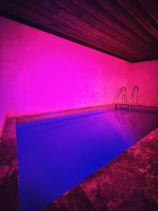 a swimming pool with pink and blue lighting at Sakli Cave House in Avanos