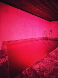 une chambre avec un mur rose et deux cintres dans l'établissement Sakli Cave House, à Avanos