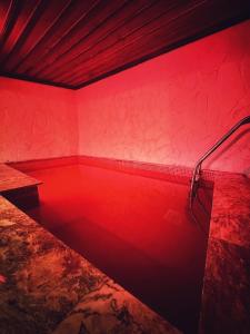 a bathtub with red lighting in a room at Sakli Cave House in Avanos