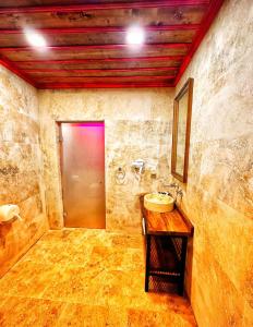 a bathroom with a sink and a mirror and a door at Sakli Cave House in Avanos