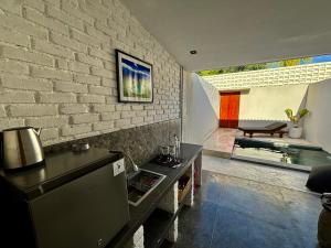 een keuken met een bakstenen muur en een tafel bij Padawatu Villas in Uluwatu