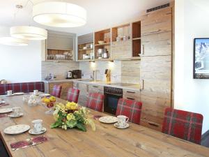 a kitchen with a wooden table with chairs and a dining room at Modern Holiday Home in Maria Alm near Ski Area in Maria Alm am Steinernen Meer