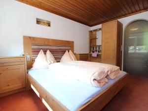 a bedroom with a large bed with a wooden headboard at Modern Holiday Home in Maria Alm near Ski Area in Maria Alm am Steinernen Meer