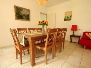 a dining room table with chairs and a vase of flowers at Lovely Farmhouse in Wijlre with Forest nearby in Wijlre