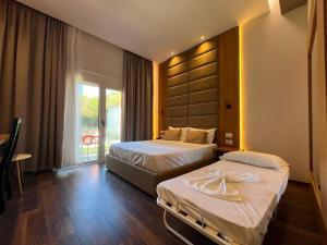 a hotel room with two beds and a balcony at Olivia's Hill Resort in Durrës