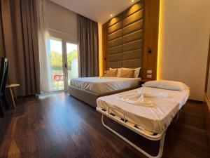 um quarto de hotel com duas camas e uma janela em Olivia's Hill Resort em Durrës