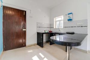 ein Bad mit einer schwarzen Theke und einem Waschbecken in der Unterkunft OYO Home Hotel Sea Prince Suites in Dona Paula