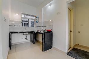 a large kitchen with a sink and a mirror at OYO Home Hotel Sea Prince Suites in Dona Paula