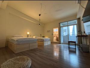 a bedroom with two beds and a large window at HomeStay LB in Taitung City