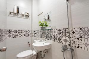 a bathroom with a toilet and a sink and a shower at Maison Bùi Viện in Ho Chi Minh City