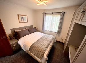 a bedroom with a bed and a window at Sunshine Lodge Haven Lakeland in Flookburgh