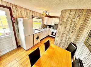 a kitchen with a table and a white refrigerator at Sunshine Lodge Haven Lakeland in Flookburgh