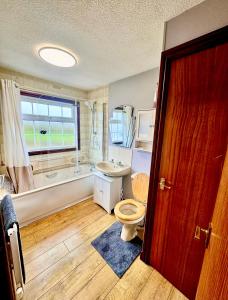 a bathroom with a toilet and a tub and a sink at Sunshine Lodge Haven Lakeland in Flookburgh