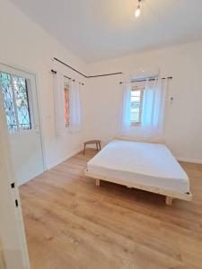 una camera da letto con un grande letto in una stanza bianca di Fellini Fortunella terrace (talpiot) a Haifa