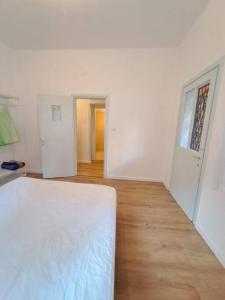 a white room with a bed and a wooden floor at Fellini Fortunella terrace (talpiot) in Haifa