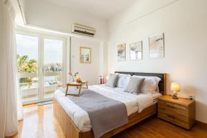 a bedroom with a large bed and a large window at Athens Luxury Getaway - Pasalimani City Oasis in Piraeus