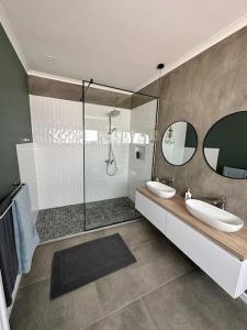 y baño con 2 lavabos y ducha. en The Elegant Beach House en Swakopmund