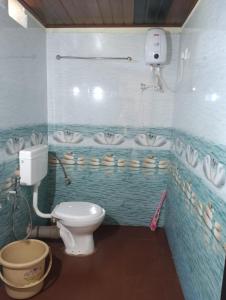 a bathroom with a toilet and sinks in it at Gokarna Govekar Sea Facing Rooms in Gokarn