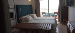 sypialnia z łóżkiem z ławką w obiekcie Seafront apartment with open-air heated pool w mieście Fuengirola +26 zdjęć