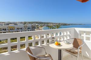 un tavolo e sedie su un balcone con vista sull'oceano di Aris Studios a Hersonissos