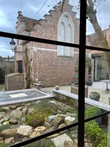 a view of a brick building from a window at B&b kleinen bosch in Beveren