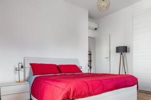 um quarto branco com almofadas vermelhas e uma cama em Verona - Sweety Apartment with Balcony! em Verona