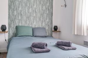 a bed with two pillows on top of it at Maison de vacances avec piscine Les Sables d'Olonne 6 personnes in Les Sables-d'Olonne