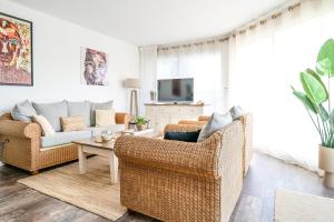 a living room with two couches and a tv at Maison de vacances avec piscine Les Sables d'Olonne 6 personnes in Les Sables-d'Olonne