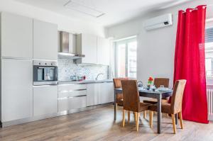 uma cozinha com uma mesa e cadeiras e uma cortina vermelha em Verona - Sweety Apartment with Balcony! em Verona