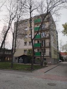 ein Gebäude auf einer Straße mit Bäumen davor in der Unterkunft Klimatyczny apartament w samym centrum Białegostoku in Białystok