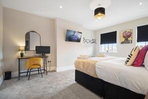 a bedroom with a bed and a desk with a computer at WhiskAwayStays - Victoria House - Apartment 6 in Worcester