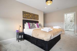 a bedroom with a large bed with a black headboard at WhiskAwayStays - Victoria House - Apartment 6 in Worcester