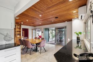 a kitchen and dining room with a wooden ceiling at Relax at Redoubt - Auckland Holiday Home in Auckland