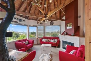 a living room with red furniture and a fireplace at Relax at Redoubt - Auckland Holiday Home in Auckland