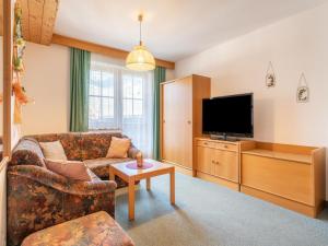 ein Wohnzimmer mit einem Sofa und einem Flachbild-TV in der Unterkunft Beautiful apartment in Mittersill with balcony in Mittersill